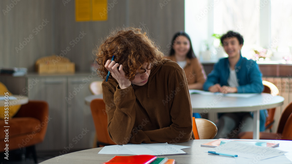 Obraz premium School academy college class lesson upset frustrated pupil student male guy boy studying learning in classroom Caucasian classmates bullying mocking throwing crumple papers balls bully discrimination