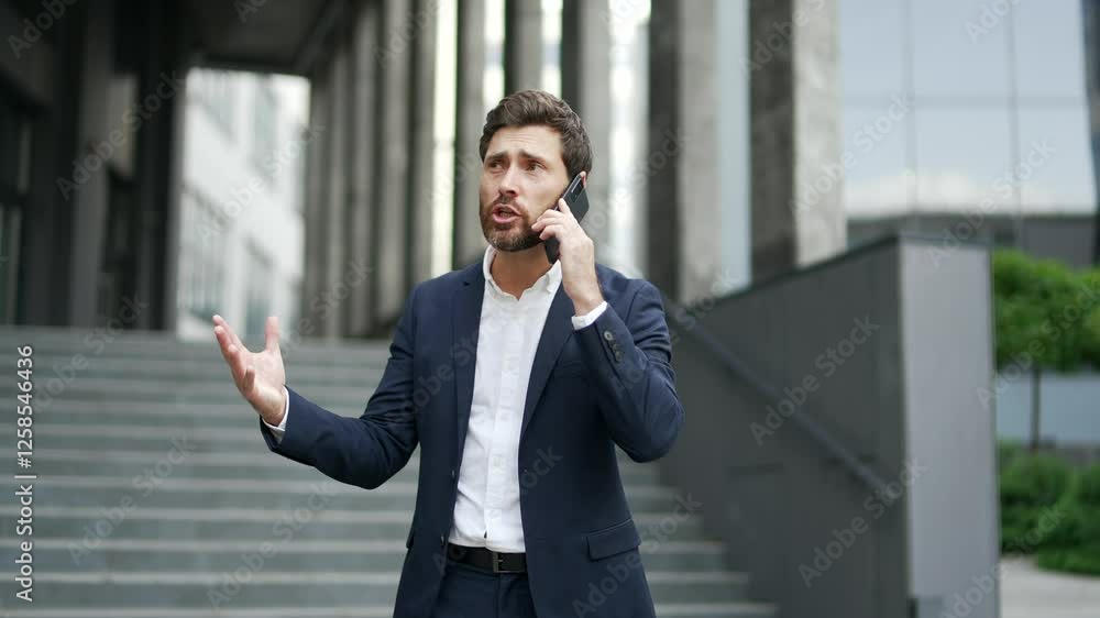 Angry excited businessman arguing talking on phone standing on street near business office building. Dissatisfied executive emotionally talks with subordinate about problems that need to be solved Angry excited businessman arguing talking on phone standing on street near business office building. Dissatisfied executive emotionally talks with subordinate about problems that need to be solved