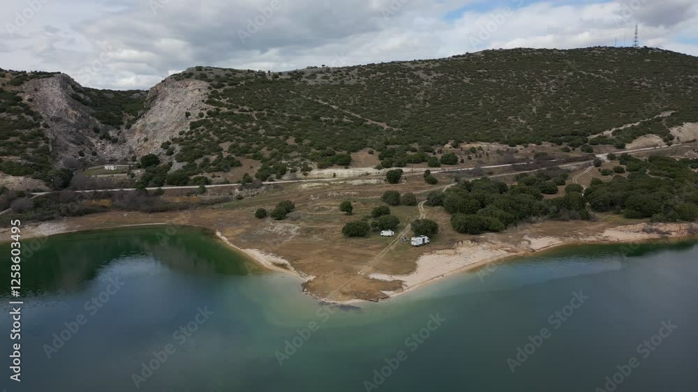 Camper vans parked on a wild spot in Lake Polyfyto drone aerial view in Greece Camper vans parked on a wild spot in Lake Polyfyto drone aerial view in Greece