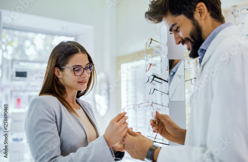 Customer tries on glasses while consulting with an eye care professional in a bright optical store