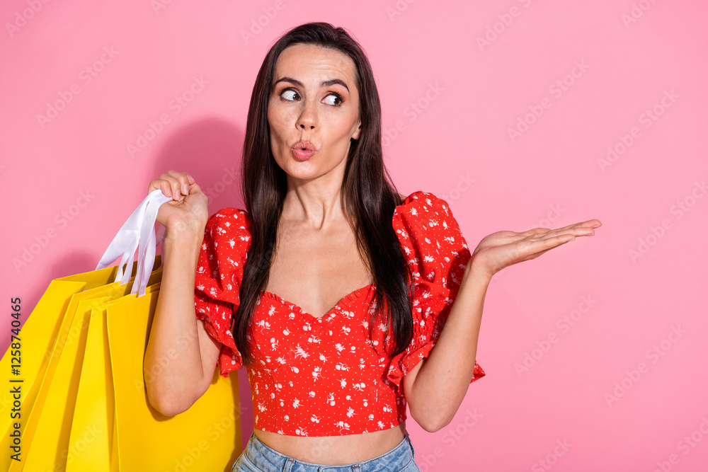 Photo of pretty young woman look hold empty space wear top isolated on pink color background Photo of pretty young woman look hold empty space wear top isolated on pink color background