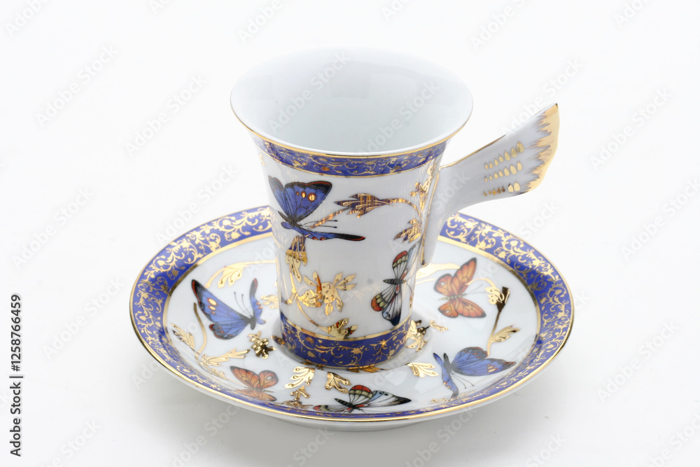 Fototapeta premium Delicate porcelain teacup featuring vibrant butterfly pattern and gilded accents, highlighting elegant tea-drinking experience
