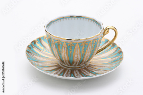 Elegant porcelain teacup sitting on matching saucer, decorated with gold and turquoise patterns