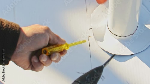 TPO (thermoplastic polyolefin) membrane installation on a rooftop for waterproofing. Construction worker using heat welding equipment to seal the membrane.