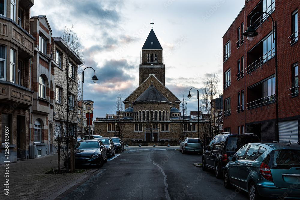 Fototapeta premium Jette, Brussels Capital Region, Belgium - Our Lady of Lourdes church and rectangular tower at sunset