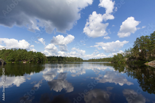 Obraz na płótnie Clouds mirrored in a lake in the Swedish national park Tyresta By near Stockholm w salonie