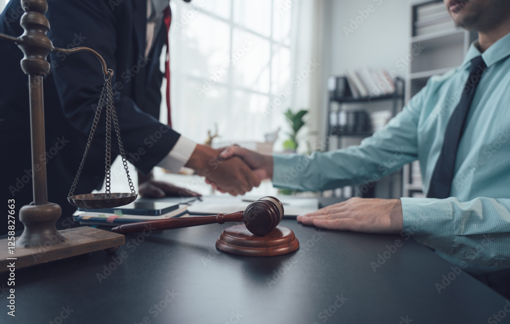 Fototapeta premium Legal Handshake: A close-up shot of a lawyer and client shaking hands across a desk, symbolizing trust, agreement, and the successful resolution of a legal matter.