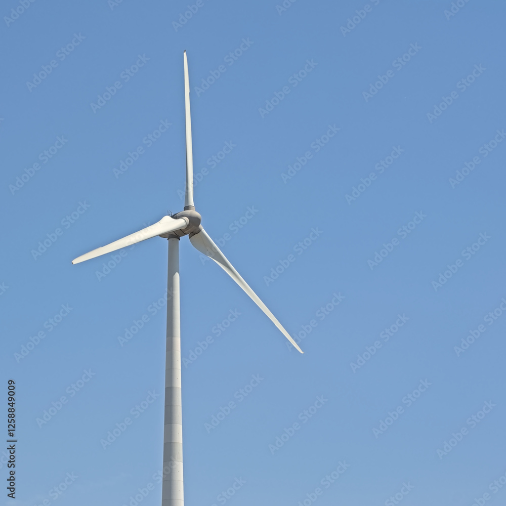 Top of a sunny wind turbine on a clear blue sky Top of a sunny wind turbine on a clear blue sky