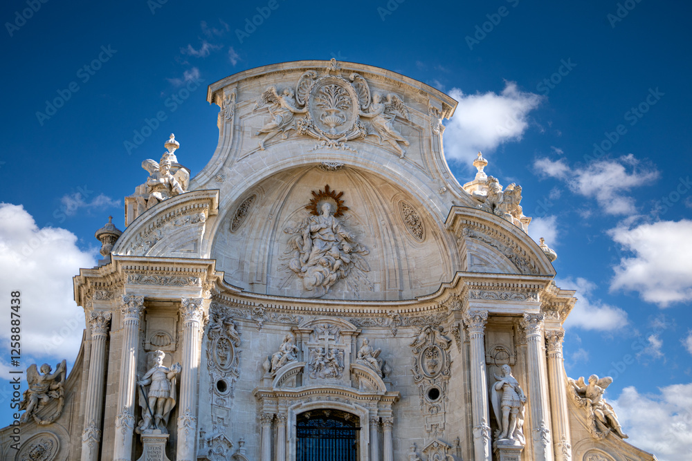 Fototapeta premium View of the top of the beautiful baroque facade of the Santa María cathedral in Murcia, Spain with blue sky and clouds
