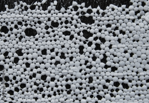 White expanding foam bubbles detail surface on black as background photo