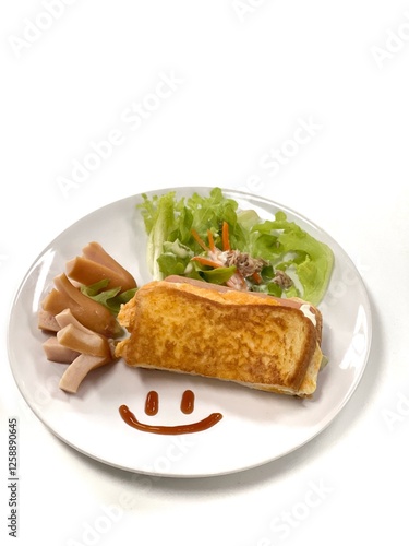 Top-down view Close-up of a breakfast plate with a smiling face made of ketchup, featuring an omelette, sausages and a salad isolated on white.