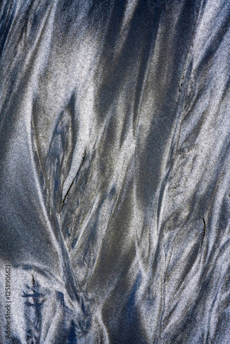 The tints and shades of black and white volcanic sand in the low tide zone. Parusnaya Bay, Iturup Island.  photo