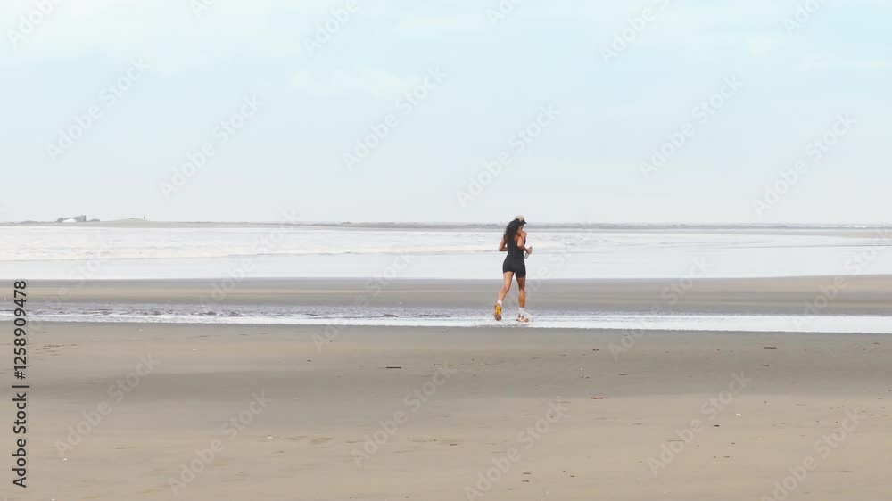 A girl jogs energetically along the beautiful Uvita Beach in Costa Rica, showcasing the serene and breathtaking beauty of Marino Ballena National Park A girl jogs energetically along the beautiful Uvita Beach in Costa Rica, showcasing the serene and breathtaking beauty of Marino Ballena National Park
