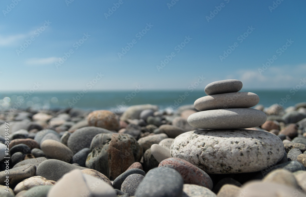 A pyramid of pebbles by the sea, embodying the concept of Zen, meditation and relaxation,a copy space A pyramid of pebbles by the sea, embodying the concept of Zen, meditation and relaxation,a copy space