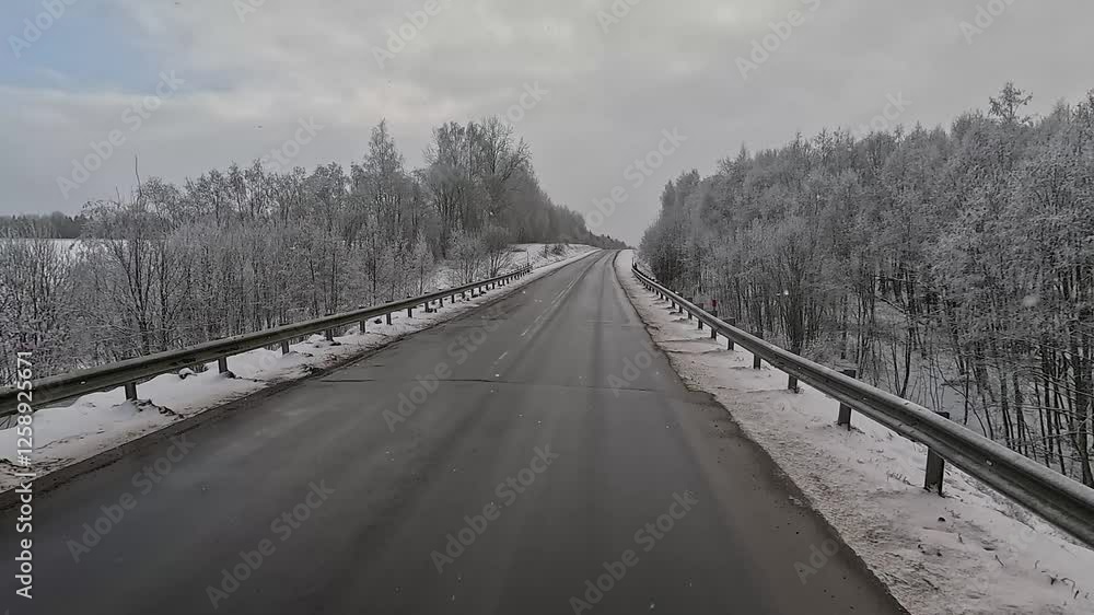 Winter road with snow, highway with cars on a sunny winter day. Winter landscape, road and shoulder covered with snow. Winter road with snow, highway with cars on a sunny winter day. Winter landscape, road and shoulder covered with snow.
