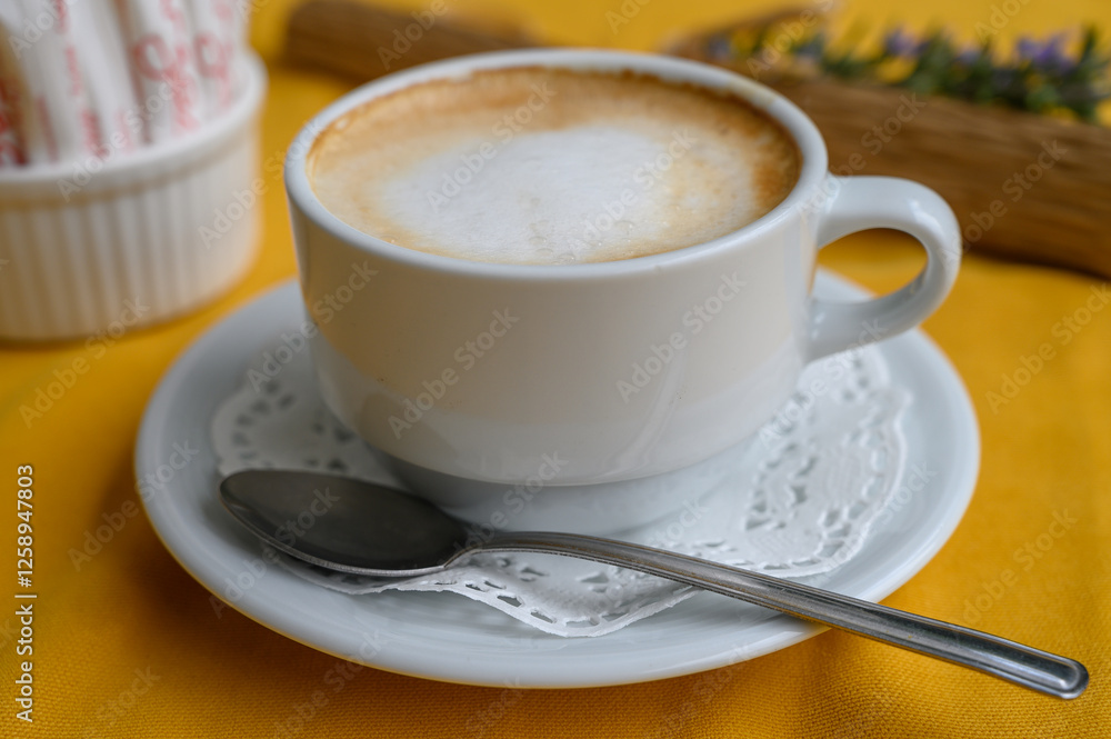 Delightful morning coffee served in a charming cafe setting with vibrant yellow tablecloth Delightful morning coffee served in a charming cafe setting with vibrant yellow tablecloth