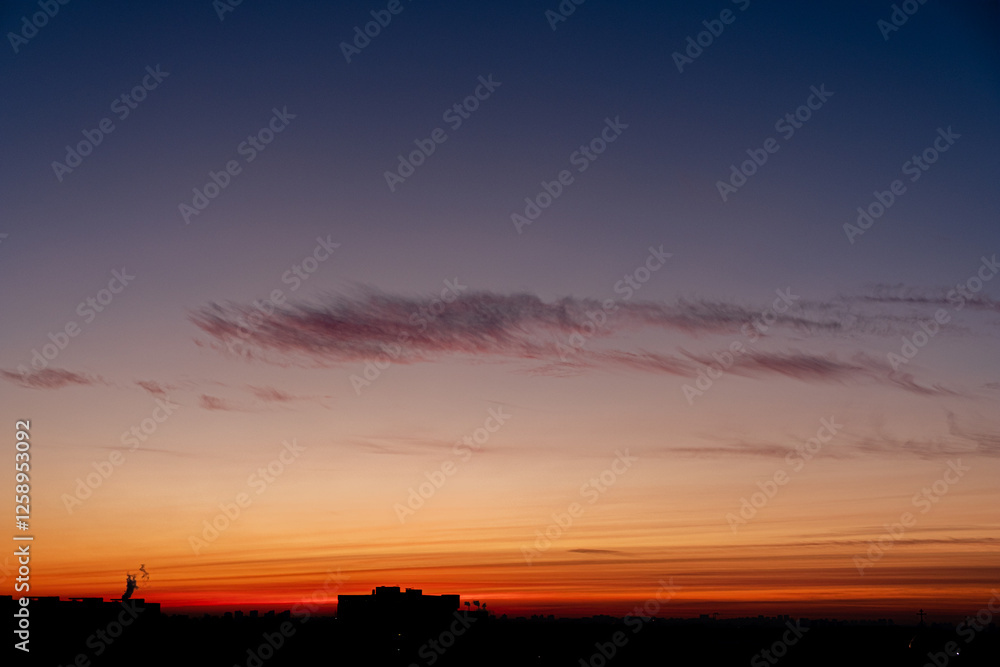 Stunning Twilight View Over the City Skyline With Vibrant Colors Transitioning From Orange to Deep Blue as the Sun Sets on a Calm Evening. Stunning Twilight View Over the City Skyline With Vibrant Colors Transitioning From Orange to Deep Blue as the Sun Sets on a Calm Evening.