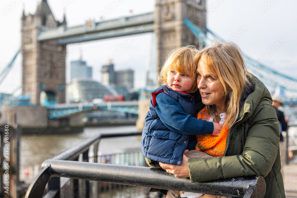 Grandmother and grandchild enjoying view of tower bridge in London, UK