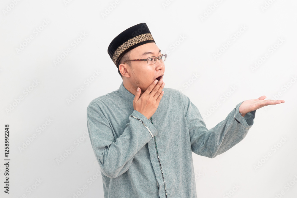 Asian Muslim man smiling showing product gesture in Ramadan Eid Al Fitr and eid adha days celebration isolated white background. Islamic celebration concept.. Asian Muslim man smiling showing product gesture in Ramadan Eid Al Fitr and eid adha days celebration isolated white background. Islamic celebration concept..
