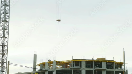 Aerial view of house construction with crane and workers in action, showcasing urban development, heavy machinery, and modern building processes. Ideal for real estate projects. High quality 4k footag