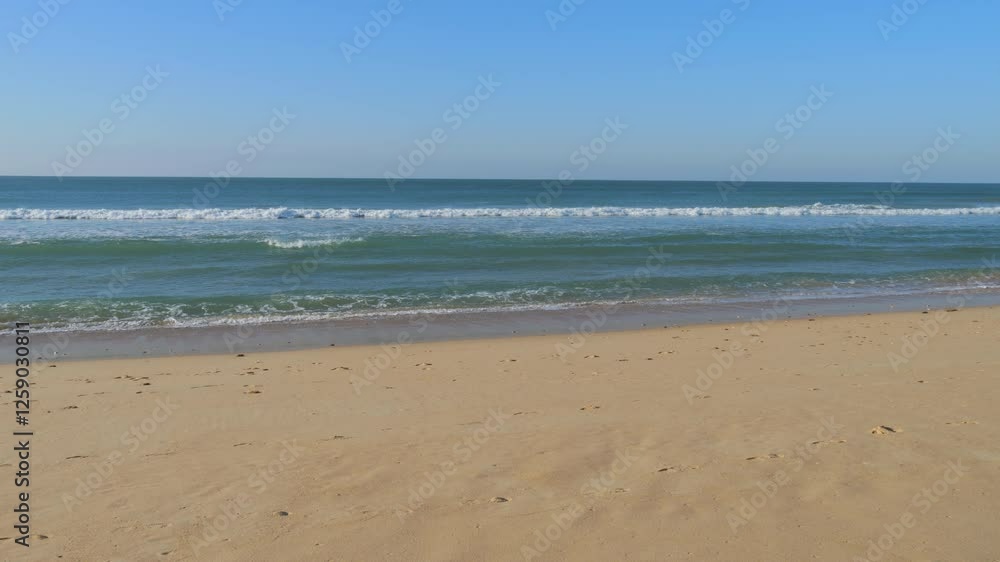 Gentle Ocean Waves Rolling onto a Sandy Beach in Portugal Gentle Ocean Waves Rolling onto a Sandy Beach in Portugal