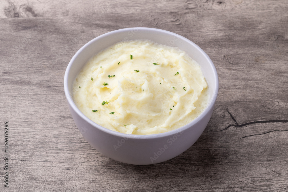 Mashed potatoes in a bowl over wooden table Mashed potatoes in a bowl over wooden table