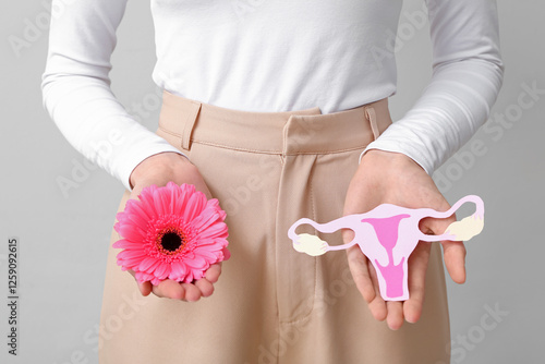 Woman holding paper uterus ...