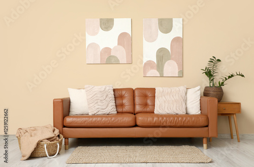 Comfortable sofa  basket with plaid and houseplant on bedside table in interior of living room