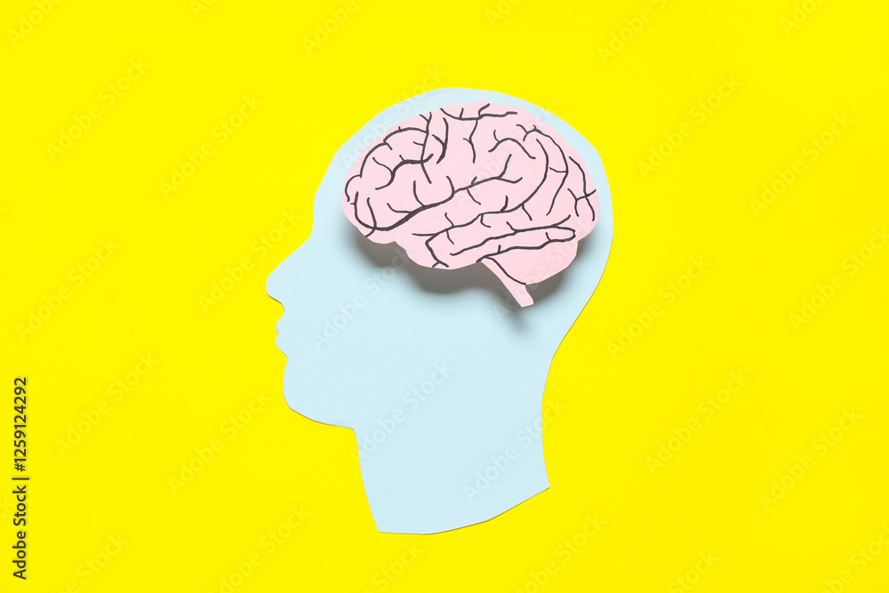 Obraz premium Paper human head with brain on yellow background. Cancer concept