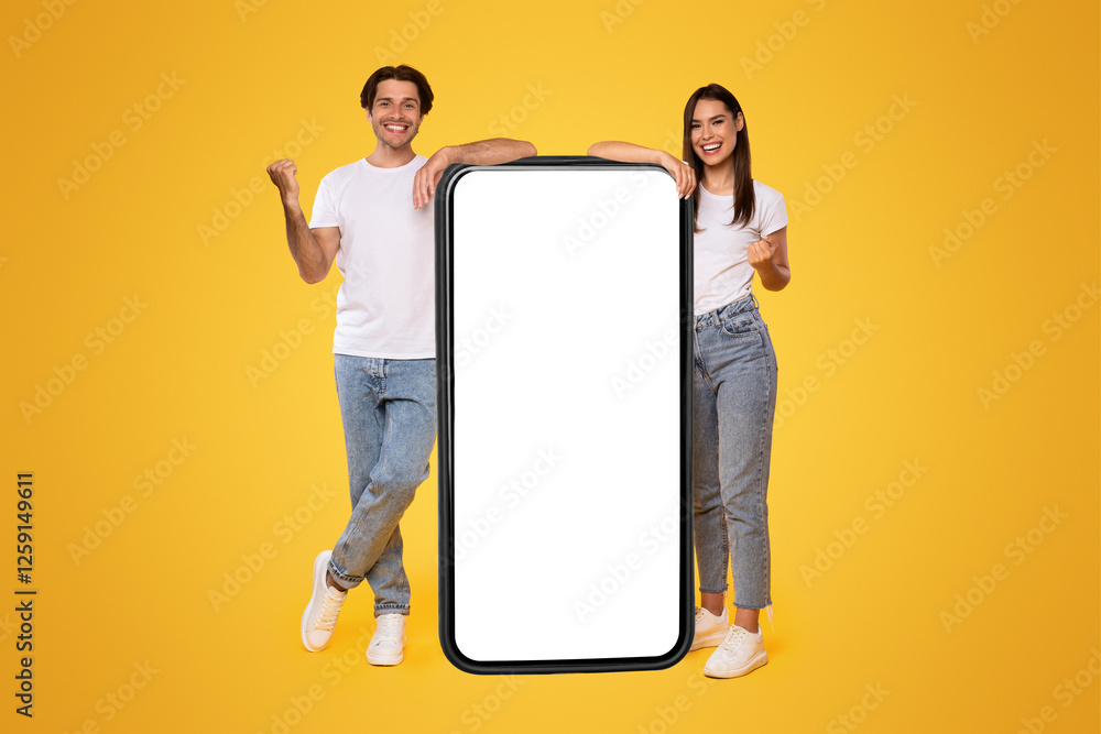 © Prostock-studio - Yes. Excited Couple Leaning On Big Smartphone With Empty White Screen Shaking Clenched Fists, Cheerful Guy And Lady Celebrating Win, Standing On Yellow Background, Mock Up Collage, Full Body Length © Prostock-studio - Yes. Excited Couple Leaning On Big Smartphone With Empty White Screen Shaking Clenched Fists, Cheerful Guy And Lady Celebrating Win, Standing On Yellow Background, Mock Up Collage, Full Body Length