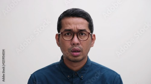 Closeup shot of a man shaking his head showing disbelief and sad face expression