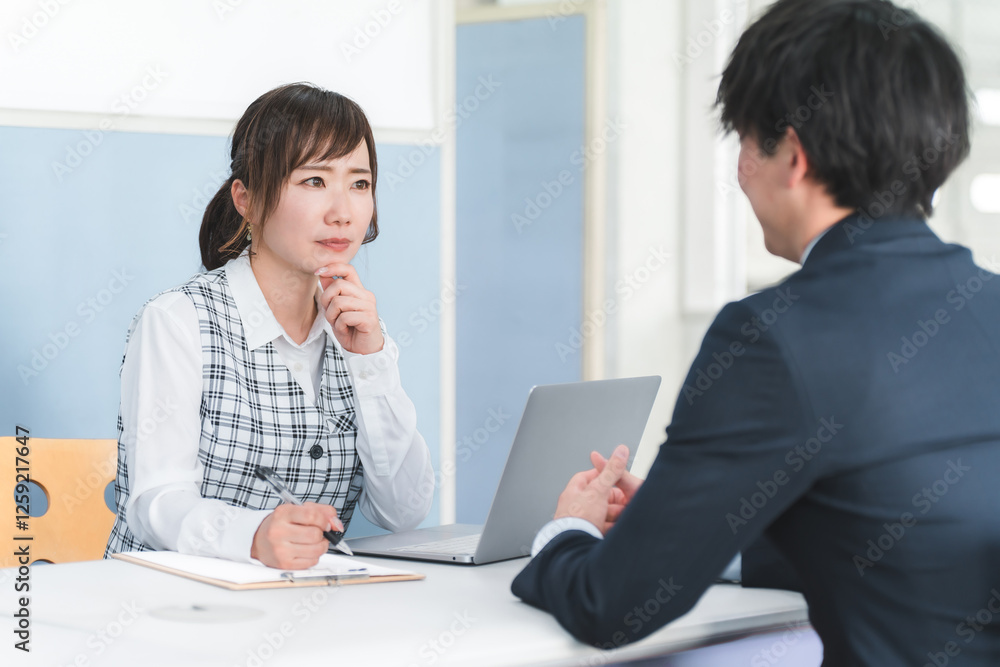 接客・顧客対応する受付嬢・事務員の女性と顧客の男性
接客・顧客対応する受付嬢・事務員の女性と顧客の男性