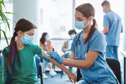 Εκτύπωση καμβά Woman doctor or nurse in protective face mask and gloves preparing to inject patient with flu antiviral vaccine, rubbing hand with cotton pad