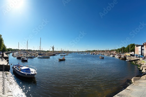 Scenic River View with Boats and Clear Blue Sky in Coastal Town photo