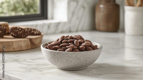 Chocolate almonds in bowl on kitchen counter with cookies photo