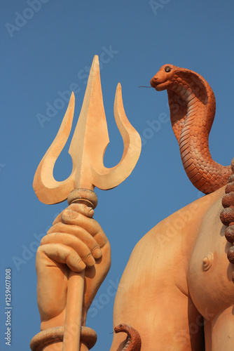 Shiva's trident and cobra against a blue sky in Gujarat, India.  Nilganagiri Mahadev Temple. photo