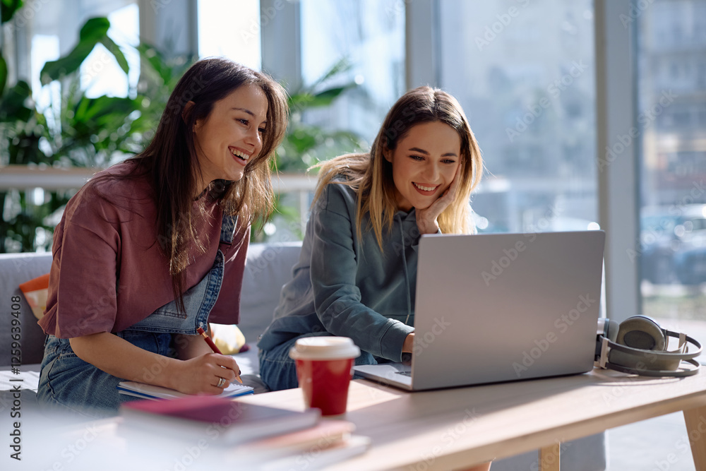 Happy female students e-learning on laptop at university. Happy female students e-learning on laptop at university.