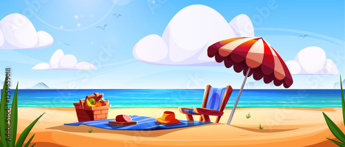 Beach picnic setup with umbrella, lounge chair and wicker basket on sandy shore. Seaside landscape with blue ocean, white clouds and distant mountain. Summer vacation scene with fruits on blue blanket