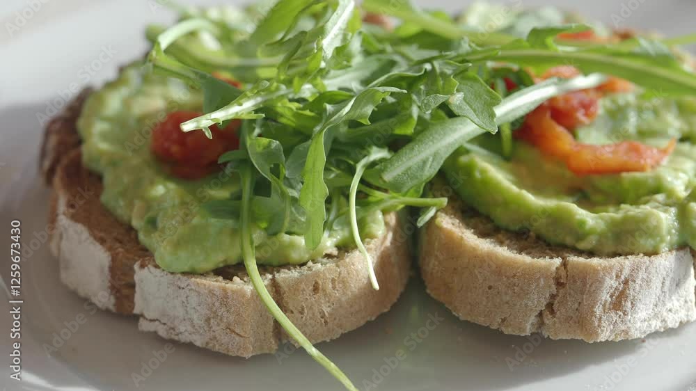 Avocado toast with fresh greens and tomatoes on whole grain bread Avocado toast with fresh greens and tomatoes on whole grain bread