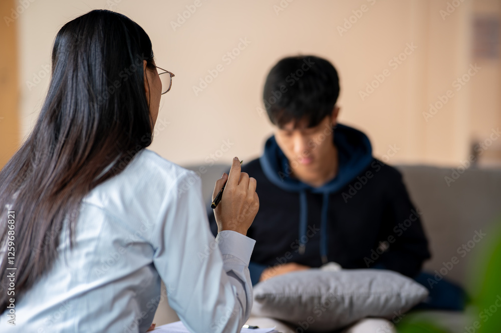 A back view of a female psychologist talking with her patient in the clinic. A back view of a female psychologist talking with her patient in the clinic.