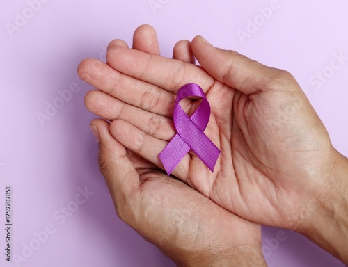 Hands holding Purple ribbons on a purple background. World epilepsy day. Alzheimer's disease, Pancreatic cancer, Epilepsy awareness, fibromyalgia awareness.