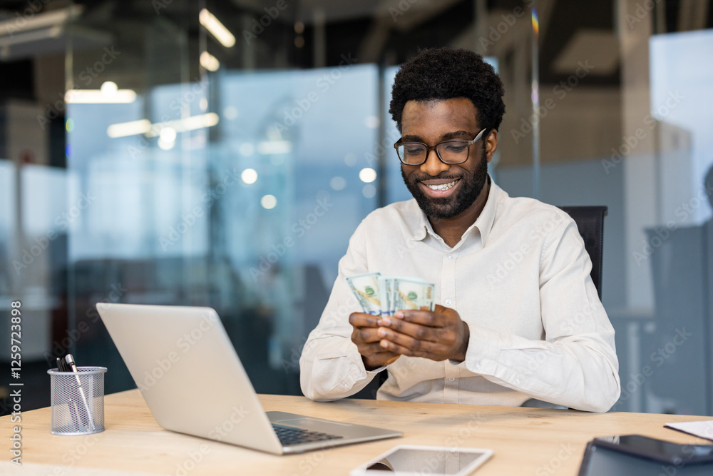 Successful businessman smiling happily counting money cash. Man holding dollars in hands, working inside office at workplace. Successful businessman smiling happily counting money cash. Man holding dollars in hands, working inside office at workplace.