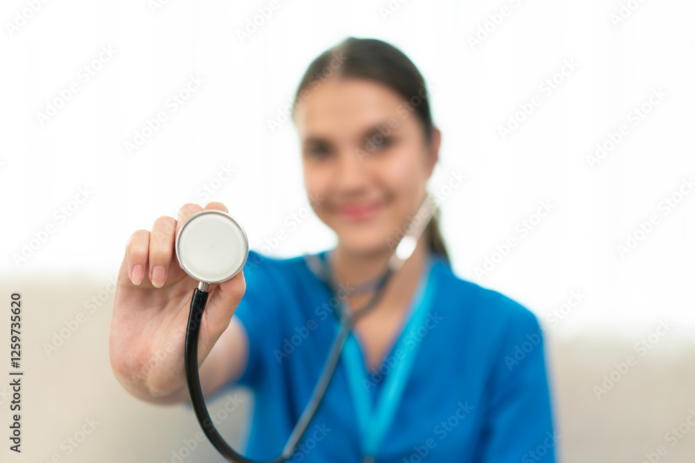 Smiling female doctor holding stethoscope forward Smiling female doctor holding stethoscope forward