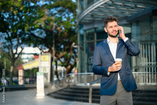 Wallpaper Mural Bearded businessman talking on mobile phone outside office building Torontodigital.ca