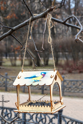 bird feeder with seeds on a tree branch in the park