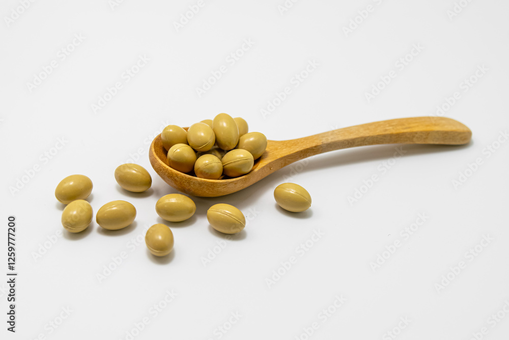 Cream colored vitamin capsules in wooden spoon