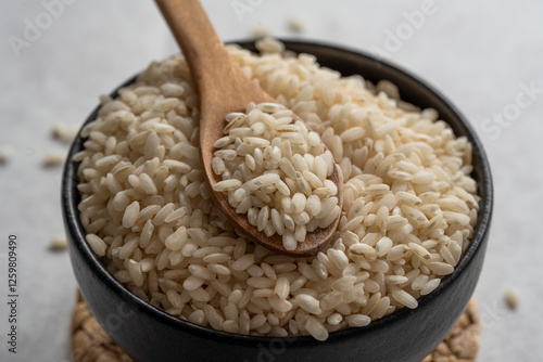 Arborio rice closeup photography. Closeup of arborio short grain rice. Rice in wooden spoon closeup.