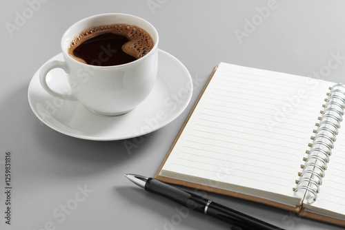 Notebook with pen and cup of coffee
