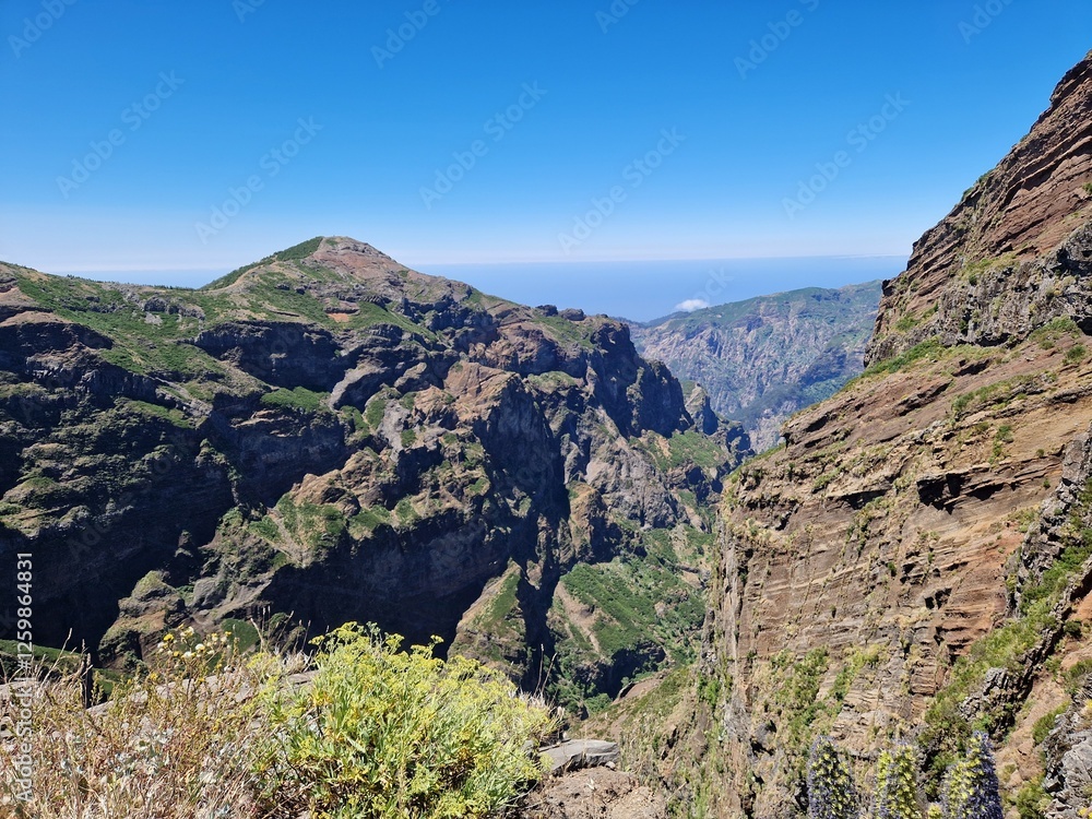 Incredible mountain landscape view, hike from Pico do Arieiro to Pico Ruivo, Madeira, steep cliffs and deep valleys, vibrant blue sky Incredible mountain landscape view, hike from Pico do Arieiro to Pico Ruivo, Madeira, steep cliffs and deep valleys, vibrant blue sky