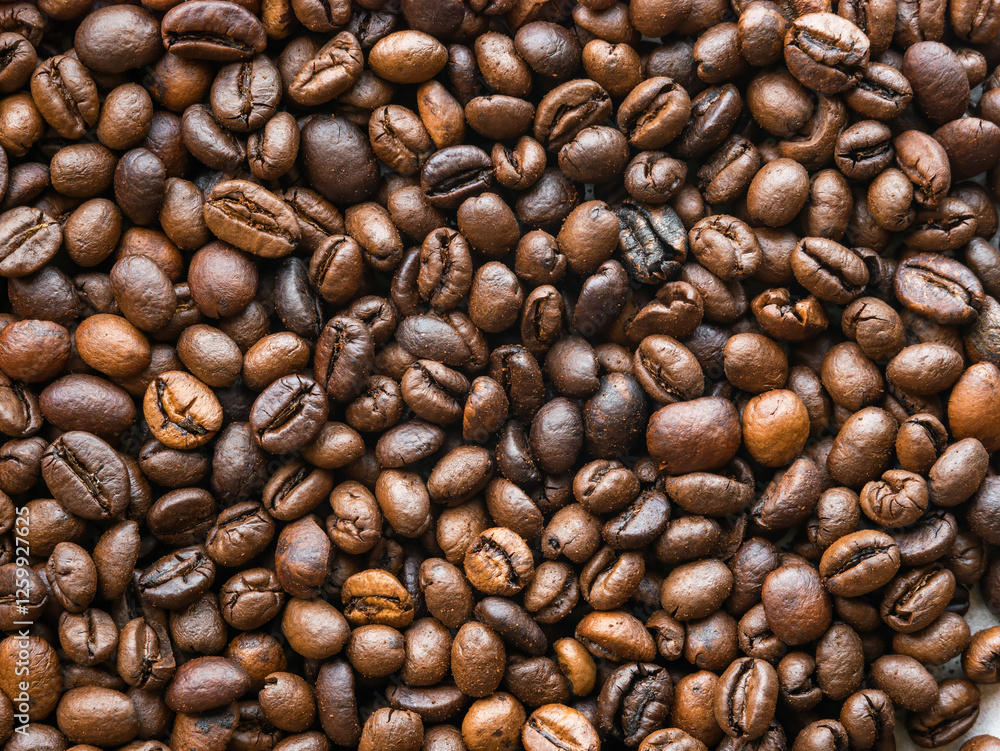 Fototapeta premium Background of scattered coffee beans, close-up view from above